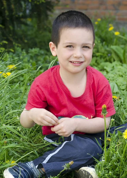 Criança feliz na grama de primavera — Fotografia de Stock