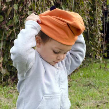 Child putting on hat Stock Photo pavsie 61228355