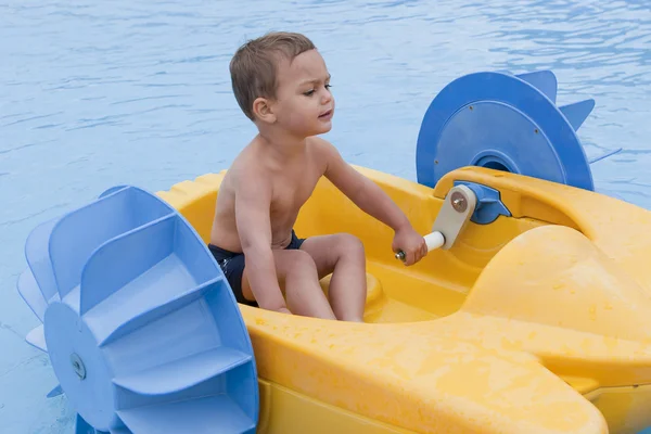 Kind op speelgoed boot — Stockfoto