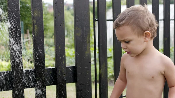 Niño con ducha de agua de jardín — Foto de Stock