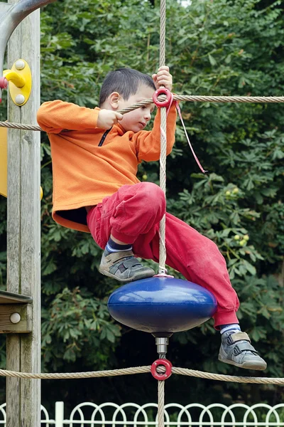 Criança escalando no parque infantil — Fotografia de Stock