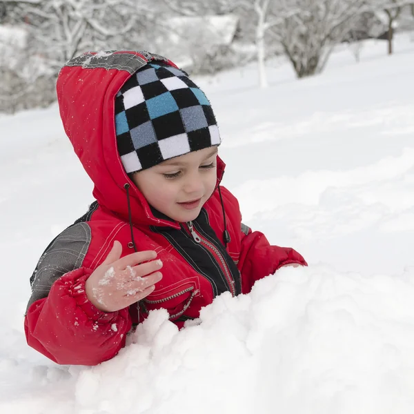 Niño jugando en la nieve — Foto de Stock