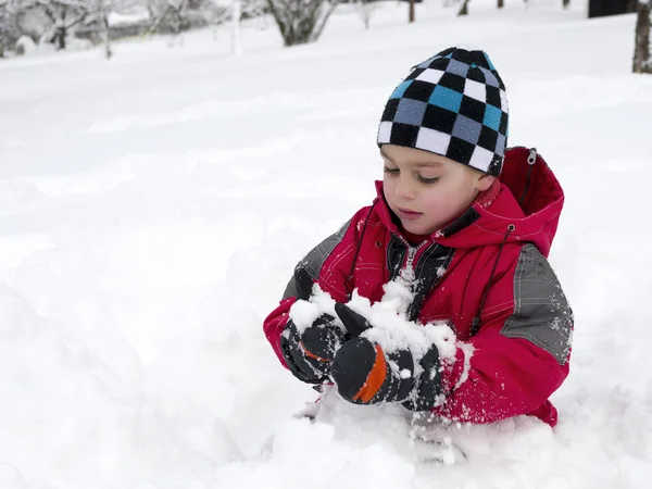 Niño jugando en la nieve — Foto de Stock