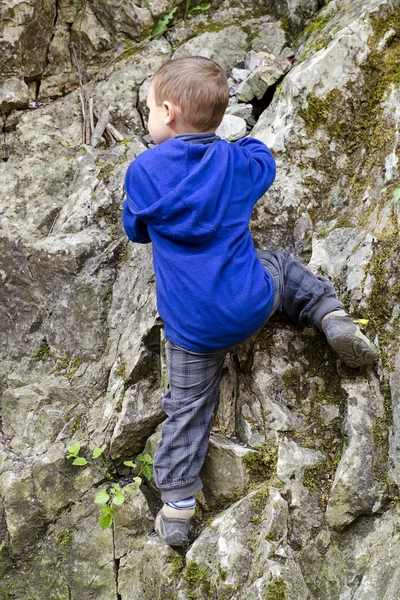 Ребенок карабкается по скале — стоковое фото