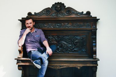 bir tahta sandalyede oturan bir adam