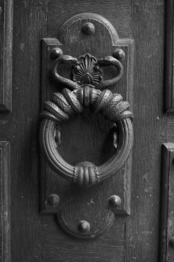 Eski ahşap kapı üzerinde Kraliyet tarzı doorknocker. Paris, Fransa. Yaşlı fotoğraf. Siyah ve beyaz.
