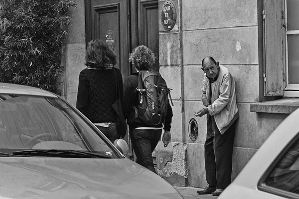 Ein älterer Mann bittet auf der Straße in Paris um Geld. schwarz-weiß. — Stockfoto