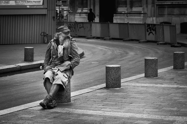 Paris, France - 17 September, 2015: Man seat on the street in Paris, Homelessness in EU reached 3 million people in 2004. Globally about 100 million people live on the street. Black and white. — Stock Photo, Image