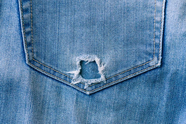 撕裂的蓝色牛仔布牛仔裤口袋里 老式的纹理 图库图片