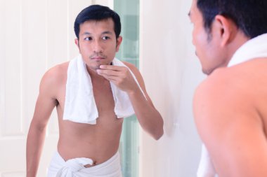 Yakışıklı delikanlı sakal yüzünü tıraş ayna ile önce dokunmadan.