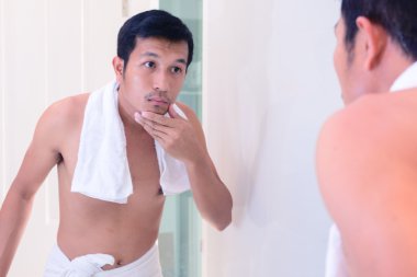 Yakışıklı delikanlı sakal yüzünü tıraş ayna ile önce dokunmadan.