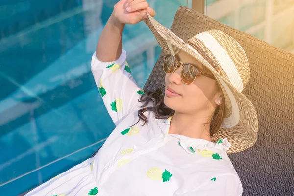Güzel Asyalı kız güneş gözlüğü yaz aylarında havuz kenarında uyuyor.