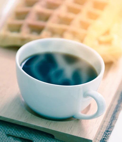 Hot coffee and waffle on wooden coaster. — Stock Photo, Image