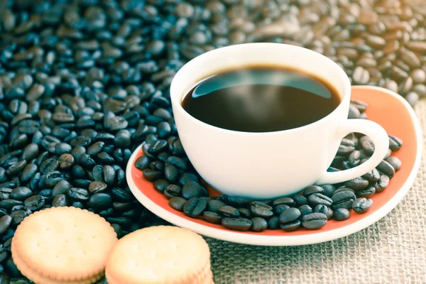 Coffee cup and cracker on sack with coffee bean, focused on a cu — Stock Photo, Image