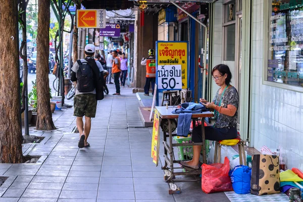 BANGKOK, THAILAND - 2016 Março 09: Mulher não identificada alfaiate trabalhando com máquina de costura na calçada em Bangkok . — Fotografia de Stock