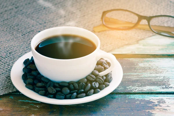 Coffee cup on wooden and sack texture with glasses background. — Stock Photo, Image