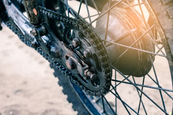 Eski kirli motosiklet zinciri üstünde tekerlek.