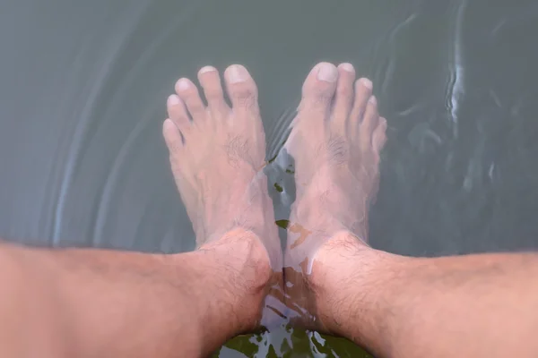 Mann verwendet natürlichen Flüssigtauchfuß, der ein guter Weg zur Gesundheit ist. — Stockfoto