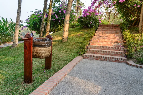 Einsatz von Bambuskörben zur Mülltrennung in der Nähe von Gehwegen im Garten. — Stockfoto