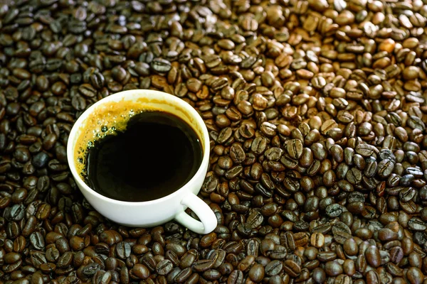 Hot americano, Black coffee in white cup with coffee beans on sa — Stock Photo, Image