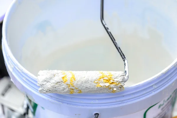 Λευκό χρώμα σε κουβά για βάψιμο τοίχου με κυλινδρικό χρωστήρα. — Φωτογραφία Αρχείου