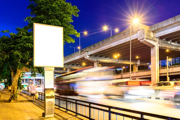 Blått annonsepanel nær vei om natten . – stockfoto