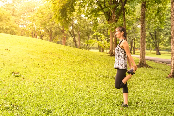 A nő runner nyújtás meleg fel állandó quadriceps szakaszon futtatása előtt oldalnézete. — Stock Fotó