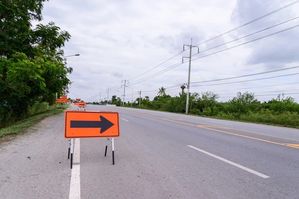 Símbolo de seta para a direita para desvio de estrada perto da estrada quebrada . — Fotografia de Stock