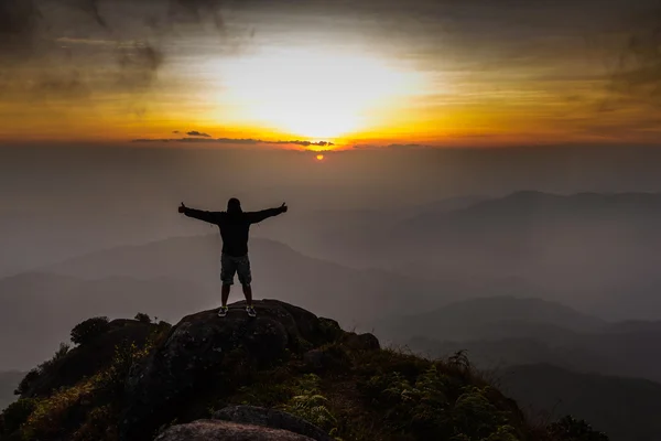 Hiker open arms on peak of mountain at sunset. — Stock Photo, Image