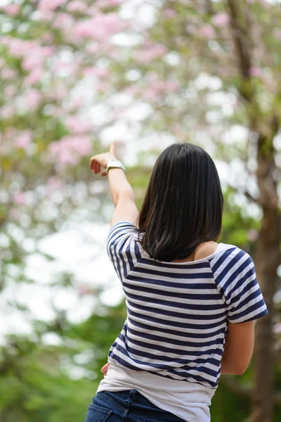 Kvinna som pekar till blommor. — Stockfoto