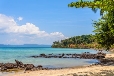 Güneşli taşlı deniz manzarası.