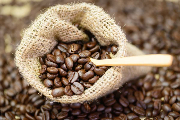 Coffee beans in bag with wooden spoon. — Stock Photo, Image