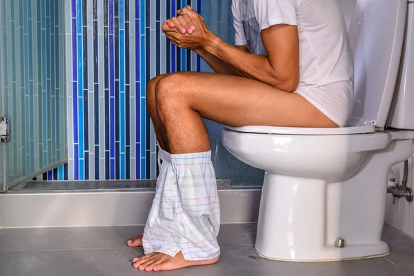Zácpu člověk vykonávající v soukromé WC. — Stock fotografie