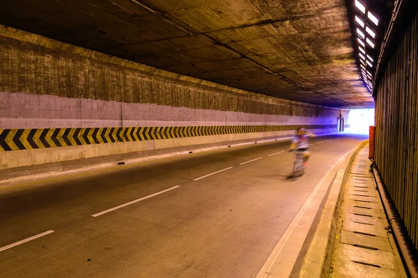 Desfoque de movimento do ciclista na estrada subterrânea . — Fotografia de Stock