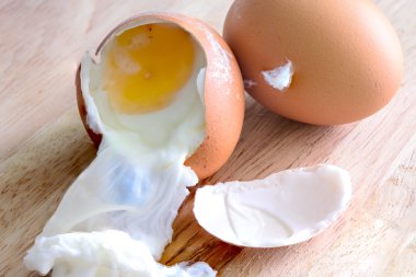 Ahşap masa üzerinde kırık haşlanmış yumurta.