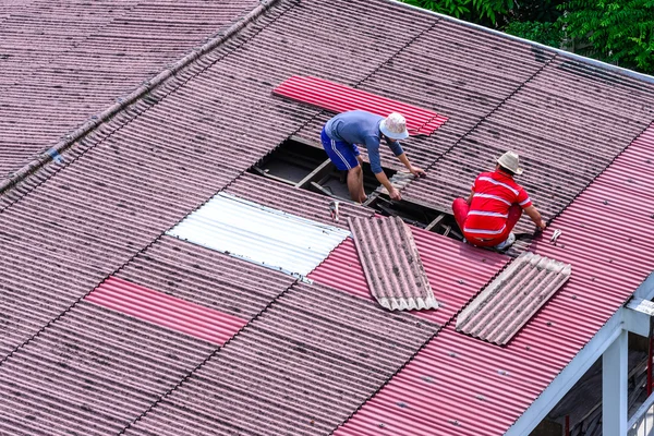 Man workers replacing damaged old tiles roof. — Stock Photo, Image