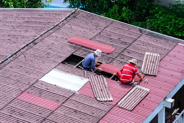 Man workers replacing damaged old tiles roof. — Stock Photo, Image