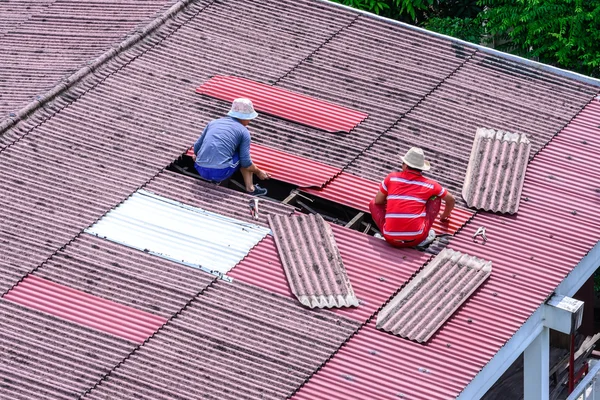 Man workers replacing damaged old tiles roof. — Stock Photo, Image