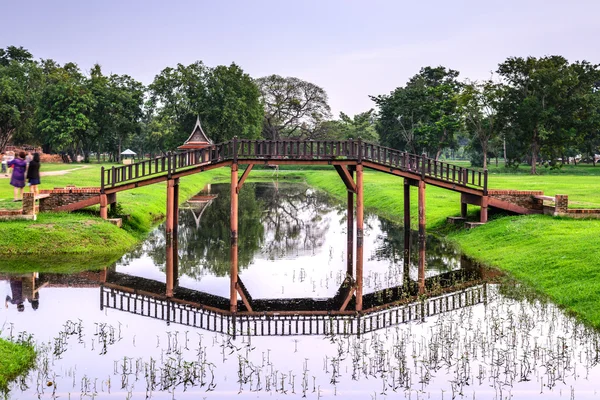 Holzbrücke über Teich in der Dämmerung. — Stockfoto