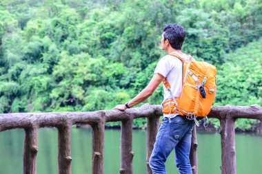 Nehir görünümünü arıyorsunuz turuncu sırt çantası ile mavi Jean adam uzun yürüyüşe çıkan kimse