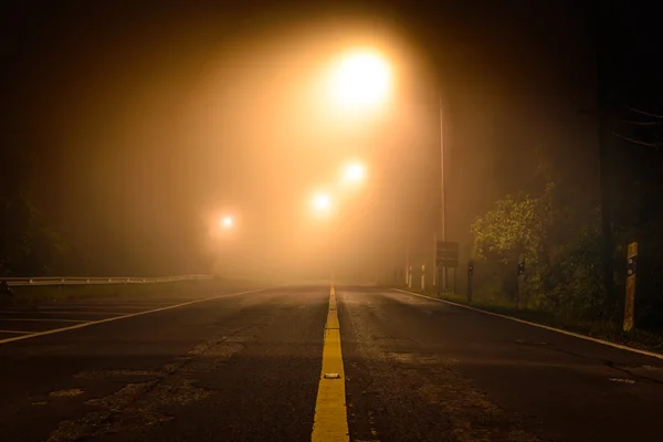 Country road with night light among the mist. — Stock Photo, Image