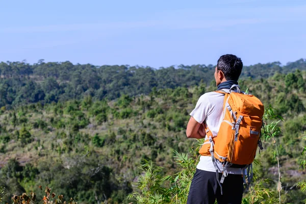 Homem caminhante com mochila laranja olhando vista da montanha . — Fotografia de Stock