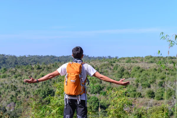Turysta człowiek z open arms plecak pomarańczowy i patrząc widok z góry. — Zdjęcie stockowe