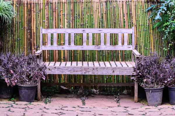 Banco de madeira entre o jardim de flores . — Fotografia de Stock