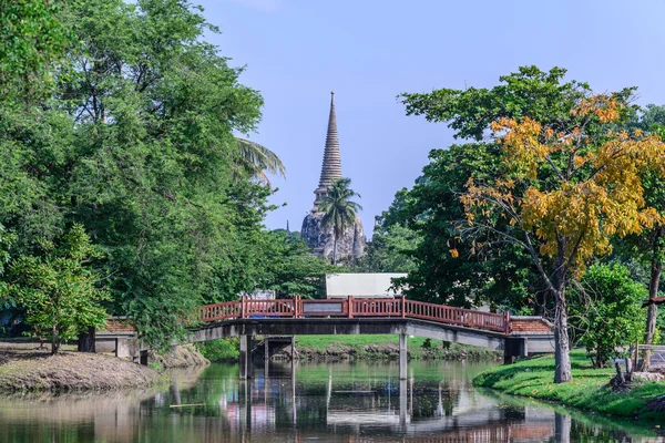 Wooden bridge over canal with Thai temple background. — Stock Photo, Image