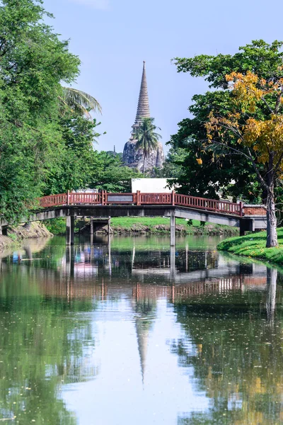 Деревянный мост через канал с тайским фоном храма . — стоковое фото