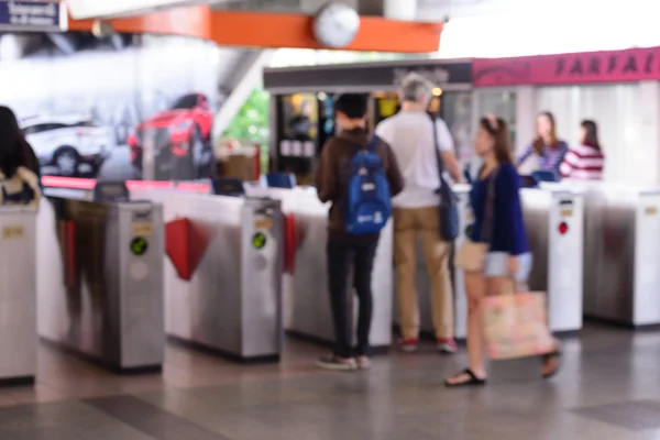 Gente borrosa usando la máquina automática de billetes en la estación de tren . — Foto de Stock