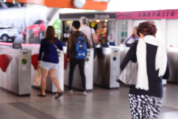 Gente borrosa usando la máquina automática de billetes en la estación de tren . — Foto de Stock