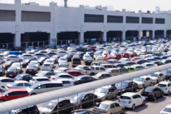 Parque de estacionamento exterior desfocado no meio da cidade . — Fotografia de Stock