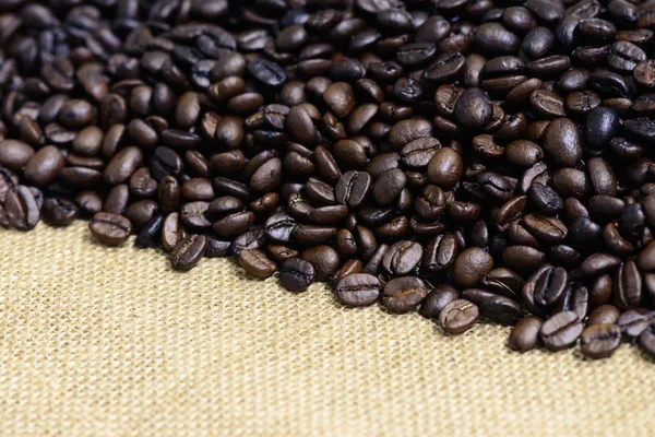 Closeup of roasted coffee bean on sack backgound. — Stock Photo, Image